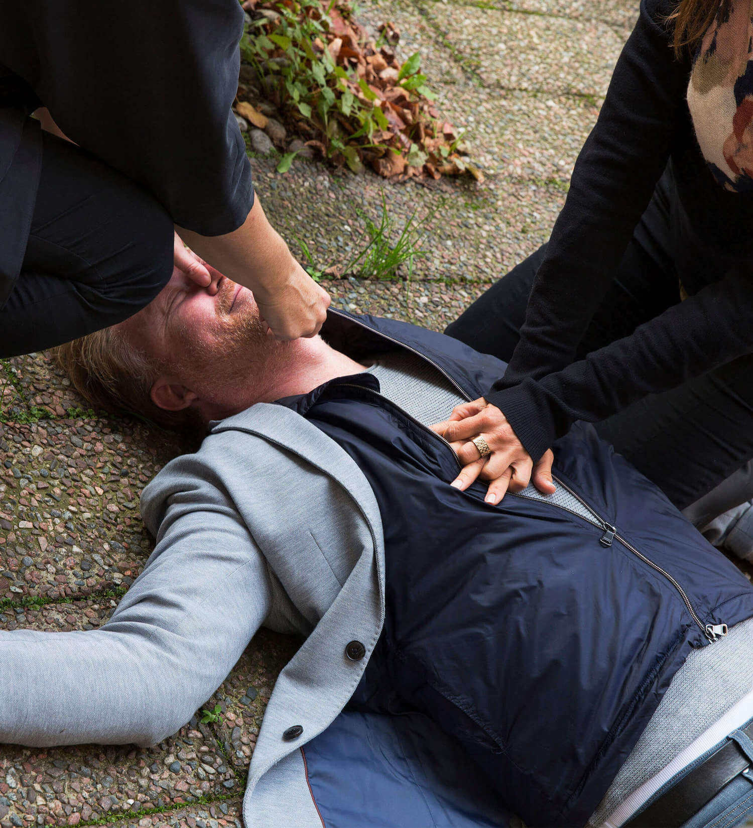 Man ligger utomhus och får hjärtlungräddning