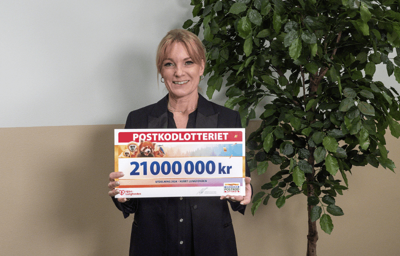 Hjärt-Lungfondens generalsekreterare Kristina Sparreljung med check från Postkodlotteriet