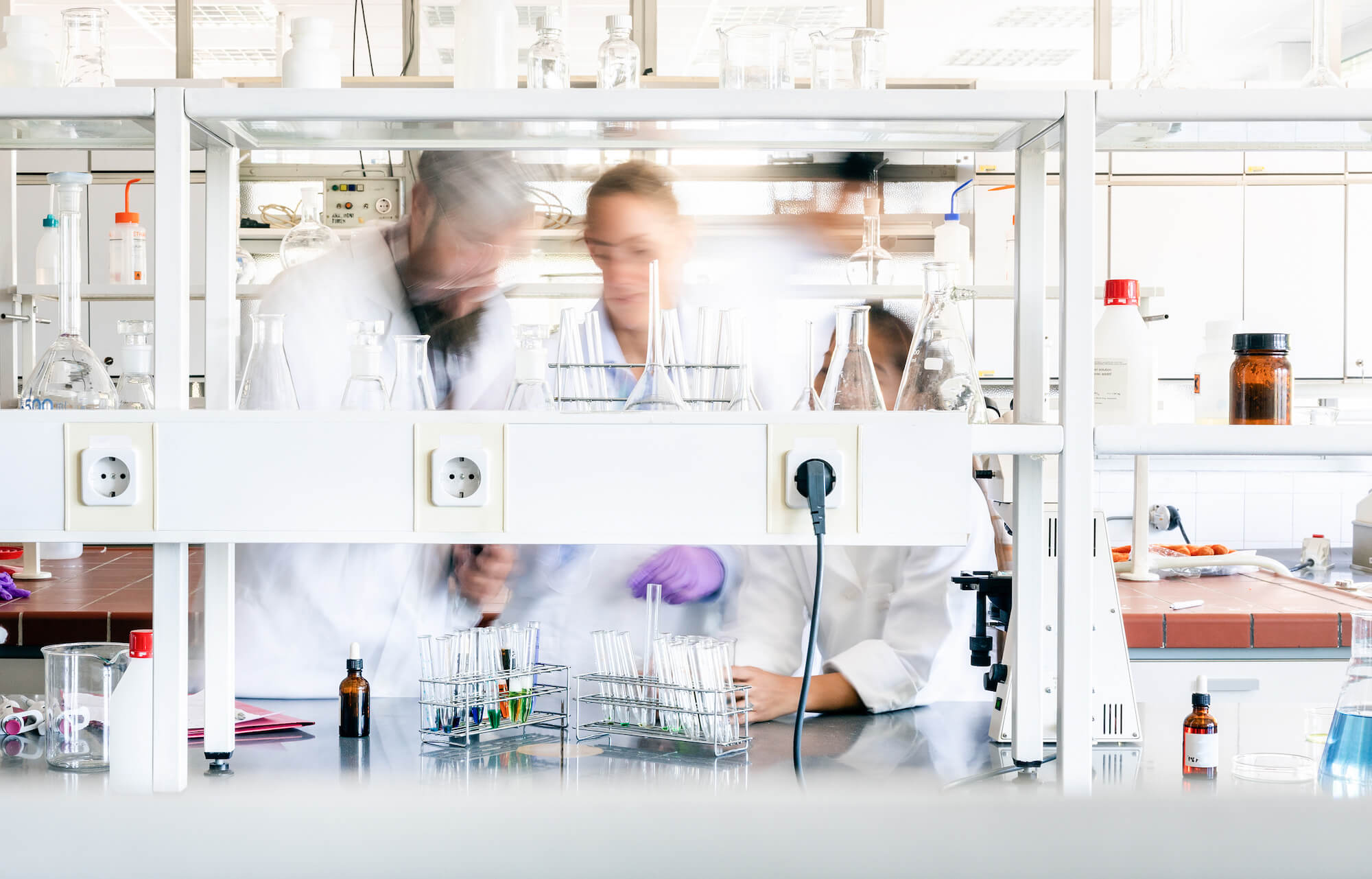 Tre forskare i forskningslaboratorium