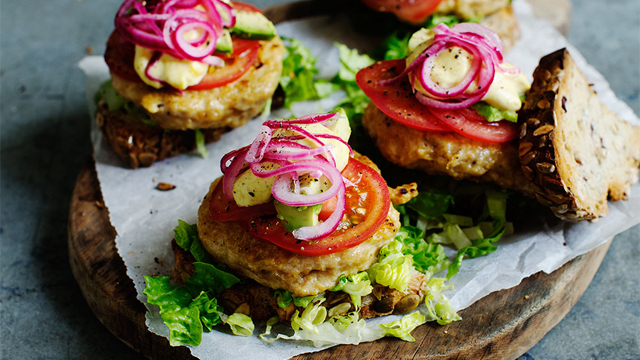 Kycklingburgare på en skärbräda.