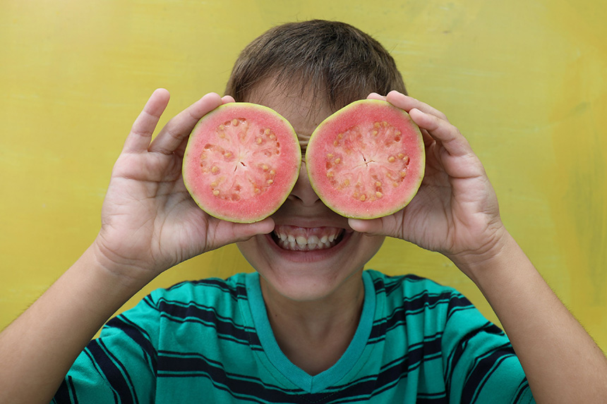 Barn håller fram frukt som ögon