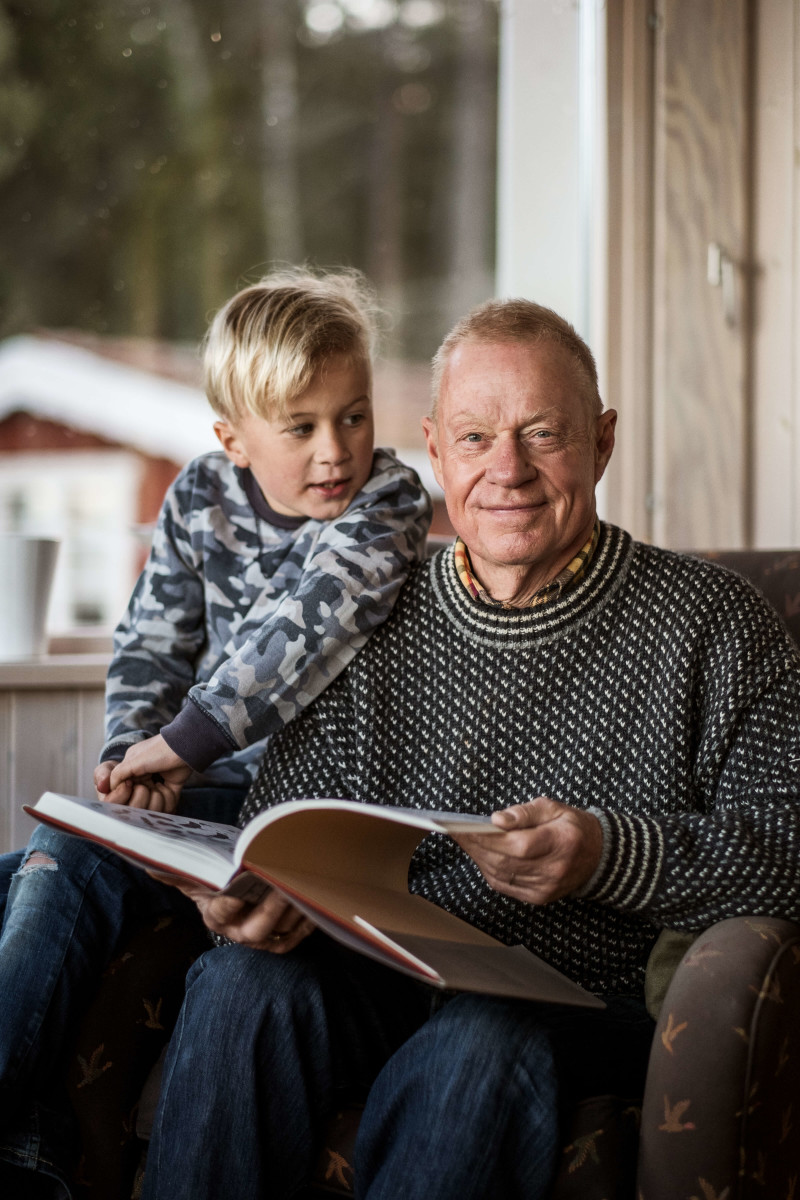 Äldre barn läser en bok tillsammans med pojke