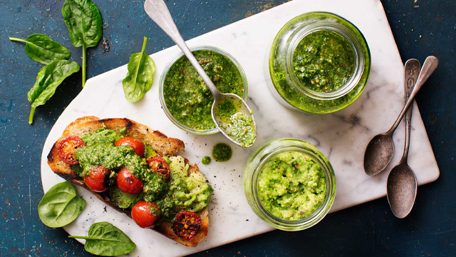 Tre olika pestos i olika burkar och skålar.