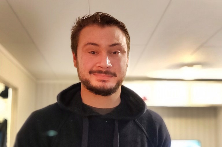 Man med kort brunt hår och skägg