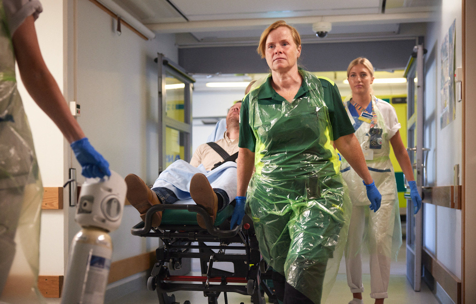 Ambulansvårdare drar bår med patient på sjukhus