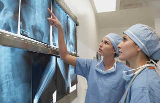 Två sjuksystrar granskar röntgenbilder