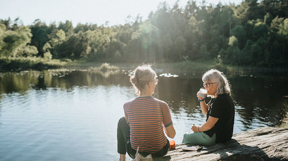 Pensionärer dricker kaffe vid en sjö