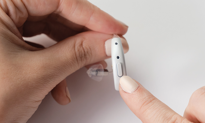 Pressing and holding the button on the right hearing aid