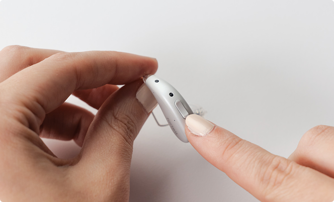 Pressing and holding the lower button on the left hearing aid
