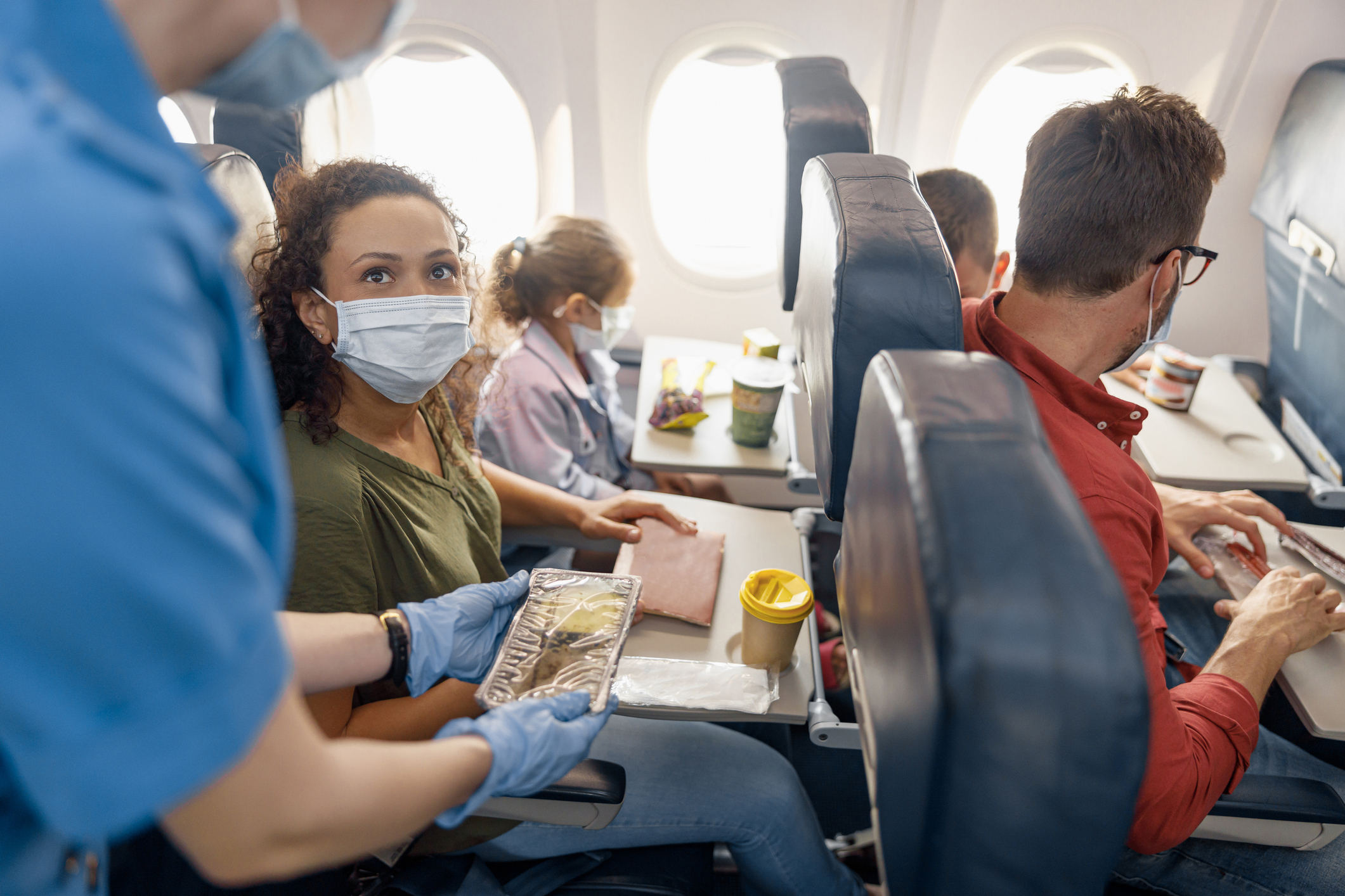Passengers on an airplane, wearing masks