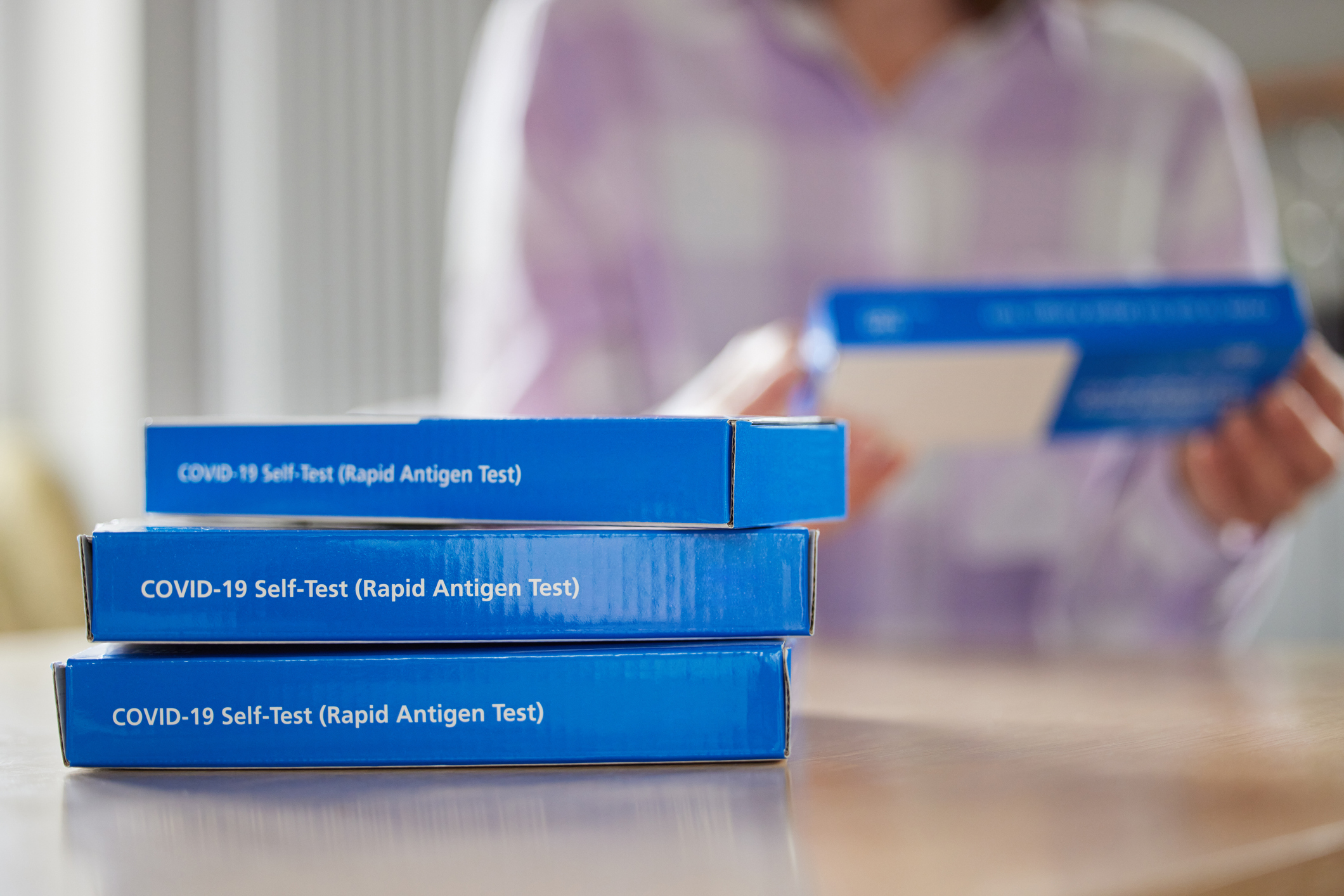 Three rapid test boxes sitting on a counter