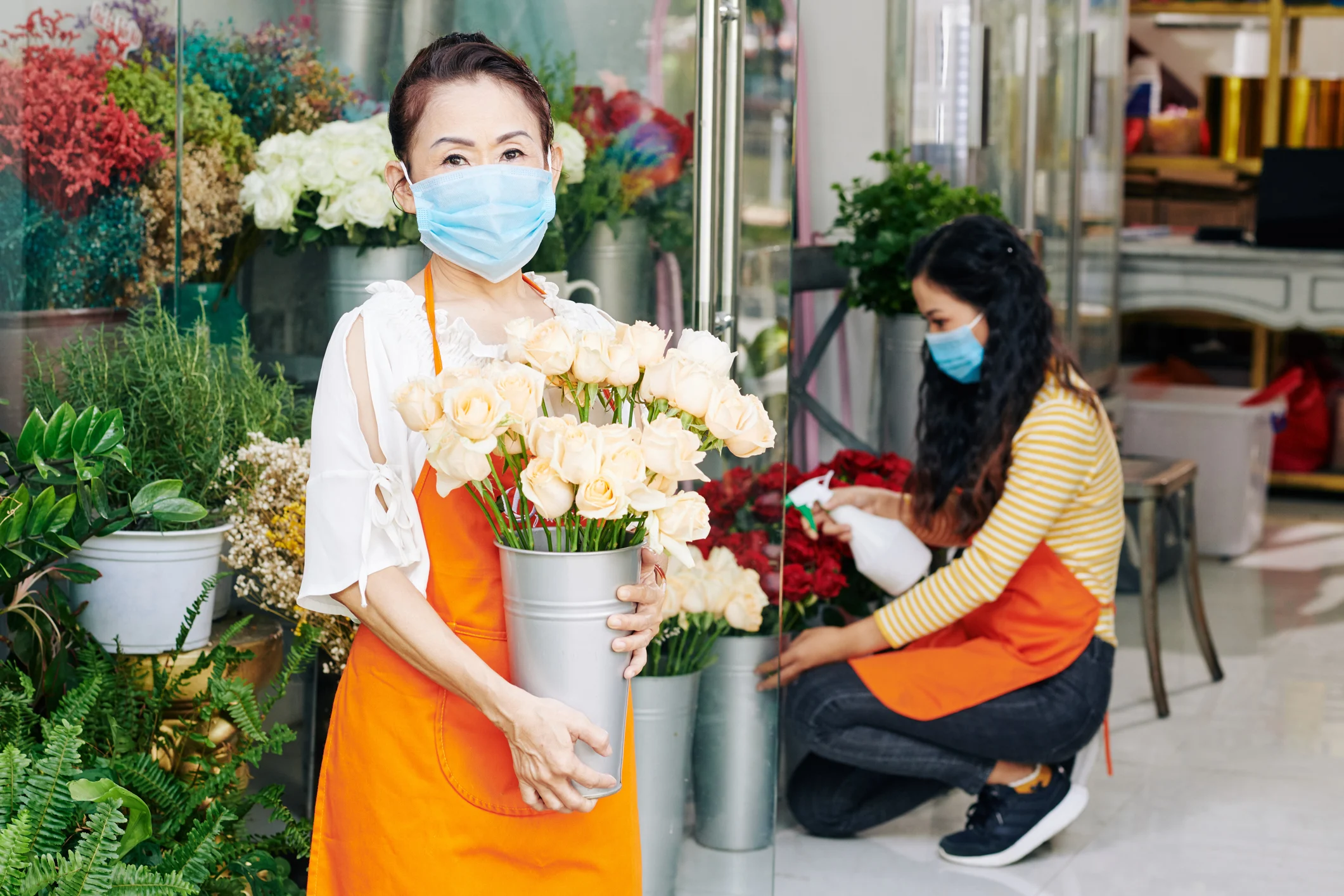 Empleados de la tienda de flores que usan máscaras