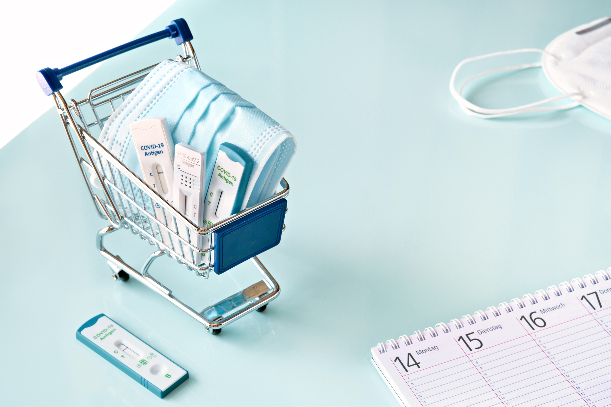 Mini shopping cart with COVID tests and masks inside