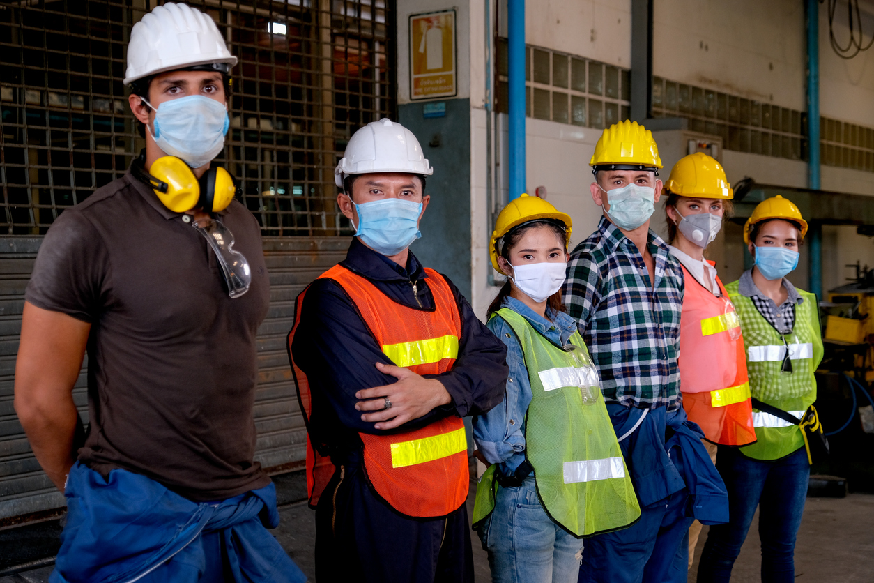 Seis hombres con cascos y ropa de construcción