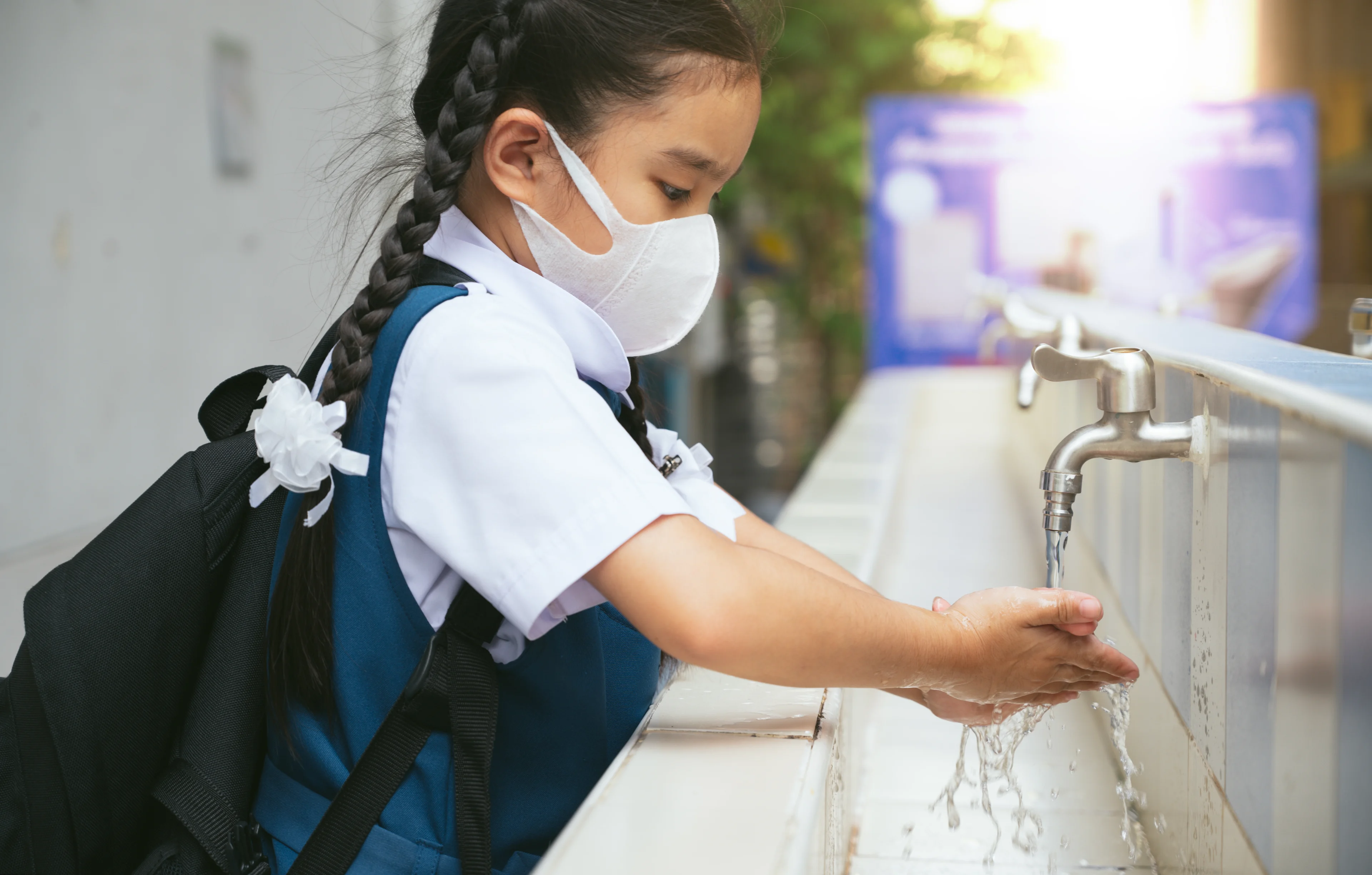 Elementary school aged girl washing hands