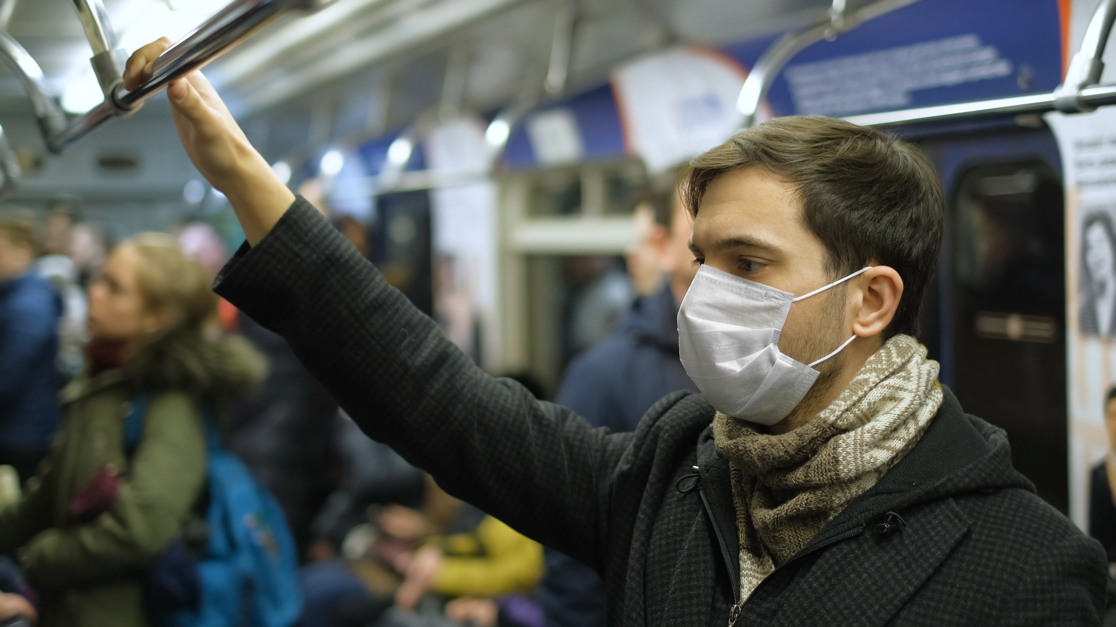 Man on subway, wearing a mask