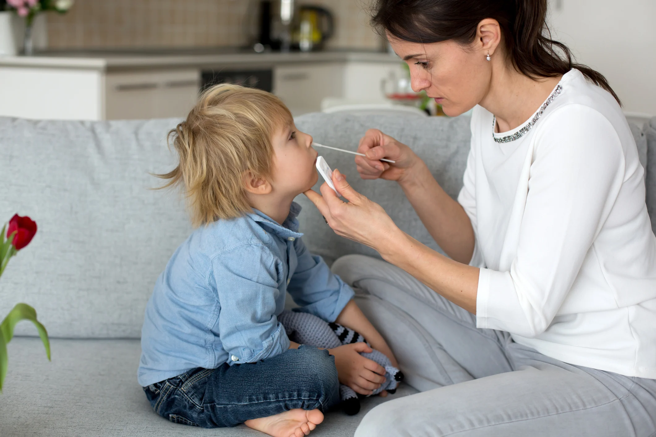 Madre dando a un niño una prueba de covid de hisopo nasal