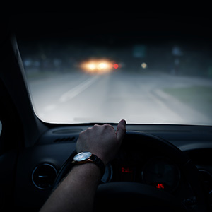 A person driving a car in the middle of the night.