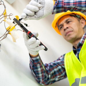 A male electrician performs a wiring installation.