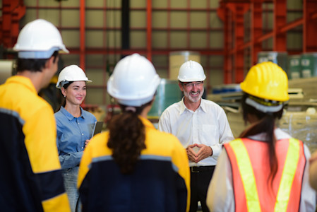 Experienced professional delivers instructor-led training to a group of employees in an industrial setting