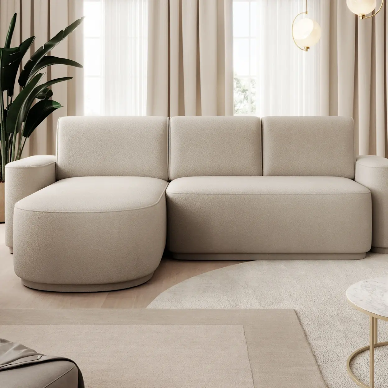 Nowoczesny salon z beżowym narożnikiem Aurumm Amore 18 o miękkich, zaokrąglonych kształtach. W tle widać jasne zasłony i duże okna, a całość dopełnia roślina oraz delikatne oświetlenie, tworząc spokojną, elegancką aranżację.