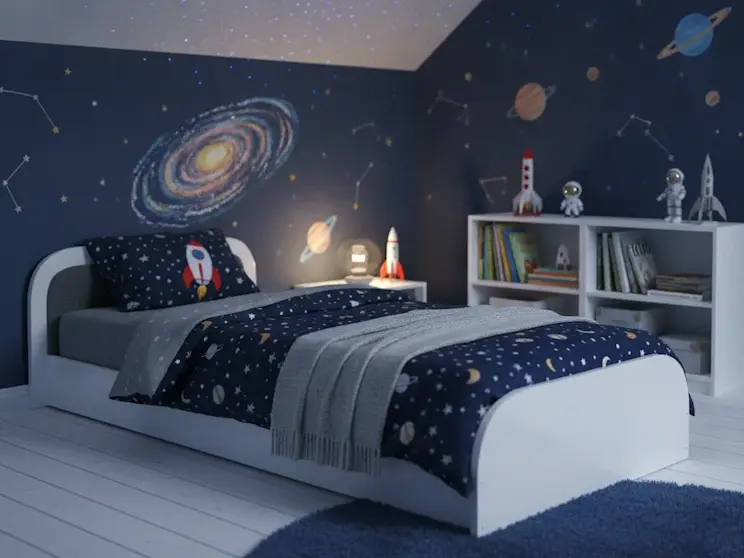 Szare łóżko dziecięce Parys zaprezentowane w nowoczesnym pokoju z motywem kosmosu. Granatowe ściany ozdobione planetami, rakietami i gwiazdami budują kreatywną atmosferę sprzyjającą zabawie, nauce oraz rozwijaniu dziecięcej wyobraźni.