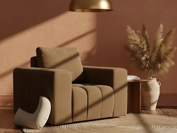 Nowoczesny fotel Lazaro Monolith 09 w jasnobrązowej tapicerce w przytulnej aranżacji salonu z lampą wiszącą i stolikiem pomocniczym.