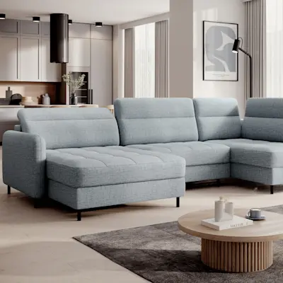 Jasnoszary narożnik Berrto w nowoczesnym salonie z aneksem kuchennym. Pikowane siedzisko i komfortowa forma do codziennego wypoczynku.