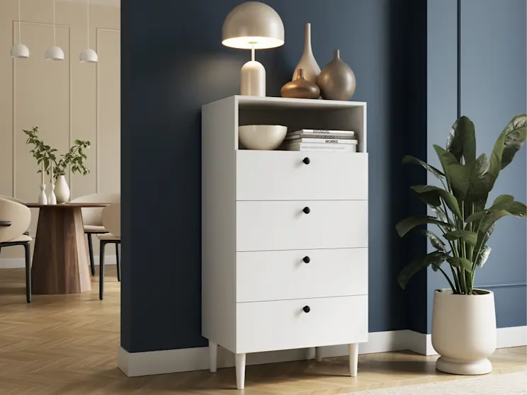 Minimalistyczne wnętrze z białym regałem Dullum. Prosta forma mebla, jasna kolorystyka i stylowe dodatki tworzą harmonijną całość.