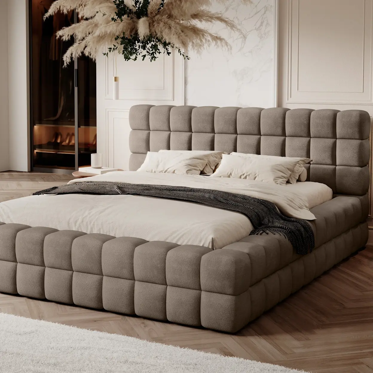 Łóżko Dizzle z miękką, pikowaną ramą i wysokim wezgłowiem, w eleganckiej sypialni utrzymanej w beżach i ciepłych naturalnych tonach.