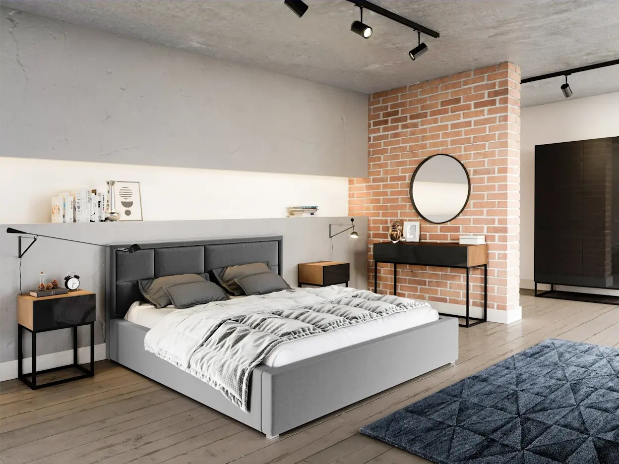 Szare łóżko tapicerowane Latina w tkaninie Sawana 21 w industrialnej sypialni z ceglaną ścianą i betonowym sufitem. Po bokach stoliki nocne, a w tle konsola z okrągłym lustrem i czarne oświetlenie szynowe.