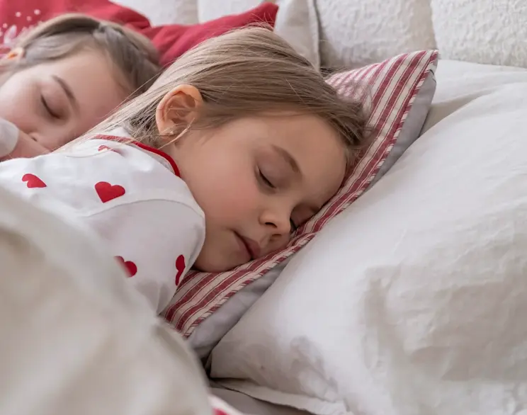 Dziewczynka zasypiająca spokojnie na materacu, który wspiera zdrowy sen i regenerację – idealny do pokoju dziecięcego.