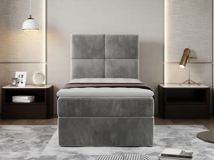 Nowoczesne łóżko Rivia Paros 05 – pojedyncze, szare i tapicerowane miękką tkaniną, z podwyższoną skrzynią oraz wysokim zagłówkiem w geometrycznym podziale. 