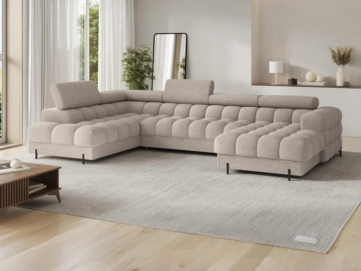 Stylowy beżowy narożnik Feraria Royal 18, komfortowy i elegancki, idealny do przestronnego salonu z dużymi oknami i minimalistycznym designem.
