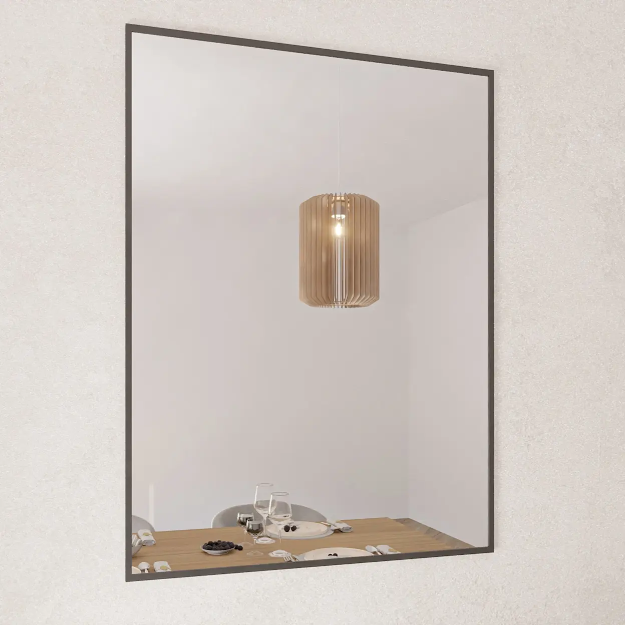 Kwadratowe lustro dekoracyjne Tressedi w cienkiej, czarnej ramie wisi na jasnej ścianie. W tafli odbija się stół w jadalni z nakryciem oraz wisząca lampa o ciepłym świetle, co optycznie powiększa wnętrze.