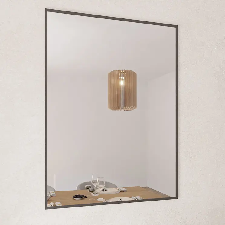 Kwadratowe lustro dekoracyjne Tressedi w cienkiej, czarnej ramie wisi na jasnej ścianie. W tafli odbija się stół w jadalni z nakryciem oraz wisząca lampa o ciepłym świetle, co optycznie powiększa wnętrze.