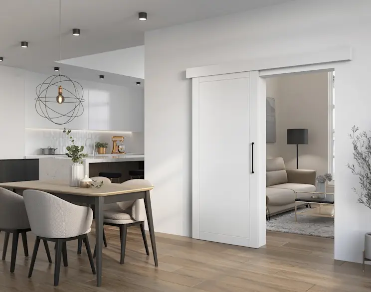 Białe drzwi przesuwne Charlise zestawione z designerską lampą Olinto w nowoczesnej jadalni połączonej z kuchnią, pełnej światła i eleganckich detali.