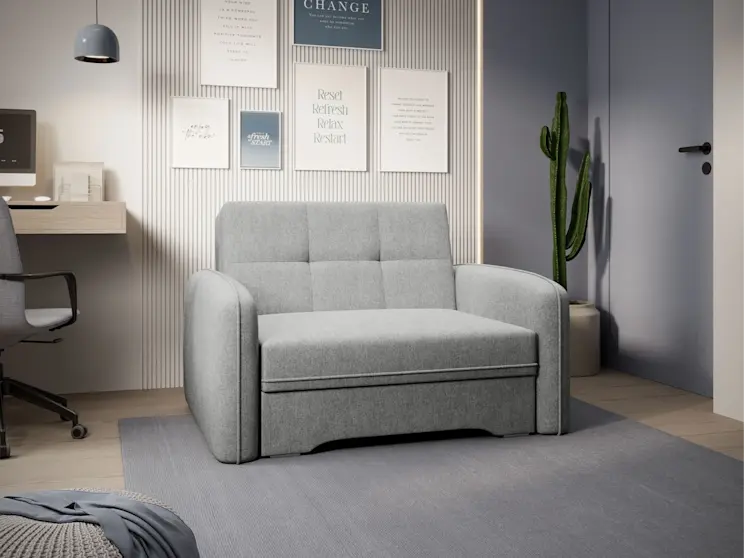 Amerykanka Laine Poco 03 – rozkładana do przodu sofa 1-osobowa w neutralnym, szarym kolorze. Ujęcie frontowe pokazuje prostą bryłę z podłokietnikami, pikowania na oparciu oraz nowoczesną aranżację z plakatami, lampą i rośliną w donicy.