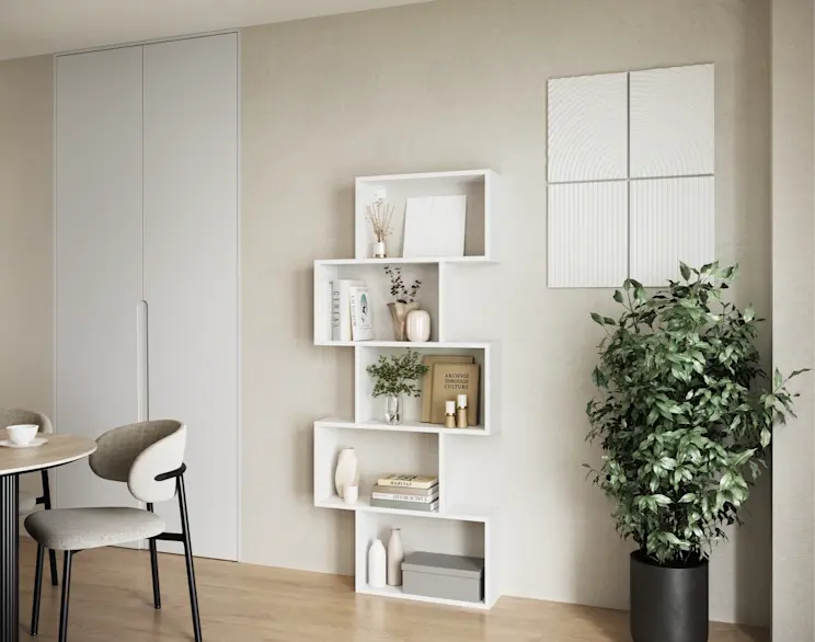 Biały regał Shellf o modułowej formie, z książkami i dekoracjami, ustawiony przy jasnej ścianie obok dużej rośliny w donicy.