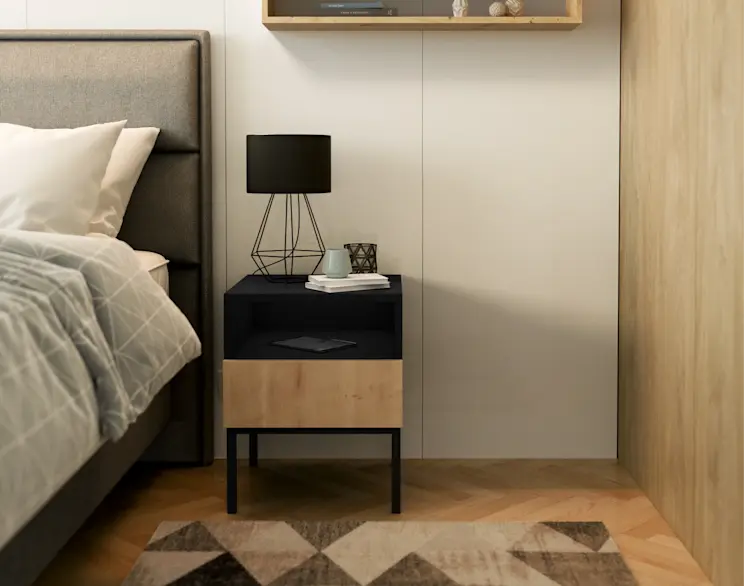 Przytulna sypialnia z tapicerowanym łóżkiem i szafką nocną Lanzzi w połączeniu czerni i drewna. Na blacie stoi lampka nocna Brevitas z geometryczną podstawą, nad całością wisi półka, a na podłodze leży dywan Eustache Beige.