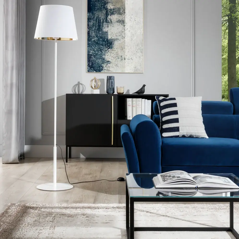 Nowoczesna aranżacja salonu z narożnikiem Kairos, białą lampą Vespillo, czarną komodą Lanzzi i szklanym stolikiem Merala.