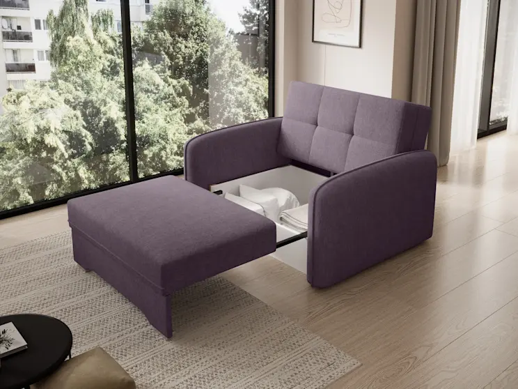 Fioletowa amerykanka Laine Poco 41 z funkcją spania i schowkiem na pościel. Na zdjęciu mebel w trakcie rozkładania: część siedziska jest wysunięta, a w środku widać pojemnik z tekstyliami; tło stanowi salon z dużym przeszkleniem.