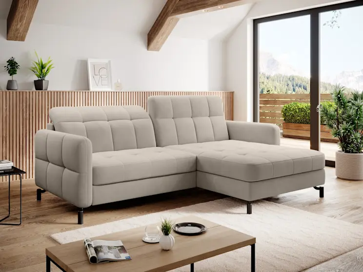 Narożnik Lorelle Paros 02 w kolorze beżowym, ustawiony na jasnym dywanie w przytulnym wnętrzu. Miękkie, szerokie podłokietniki i geometryczne przeszycia podkreślają komfort wypoczynku dla całej rodziny.