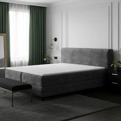 Łóżko Cortiko w ciemnej, eleganckiej sypialni z zielonymi zasłonami, złotymi akcentami i dużym lustrem.