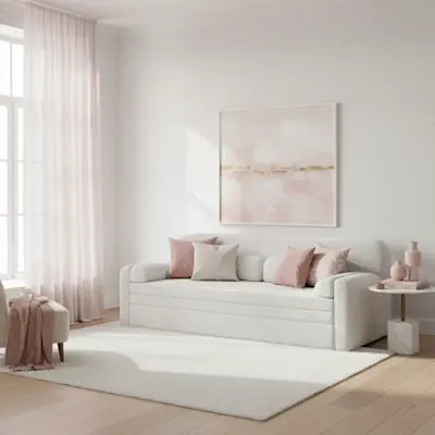 Biała kanapa Elioss w jasnym salonie z delikatnymi różowymi dodatkami. Elegancka aranżacja wnętrza sprzyjająca relaksowi i codziennemu komfortowi.