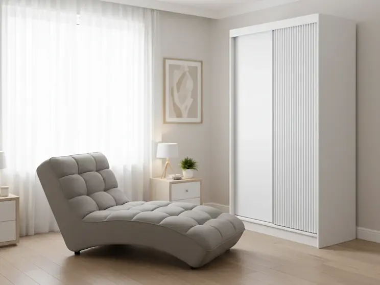 Szafa Biancco II i szezlong Loren Loco 04 w jasnym, spokojnym wnętrzu z miękkim światłem, roślinami i minimalistycznymi dodatkami tworzącymi relaksujący klimat.