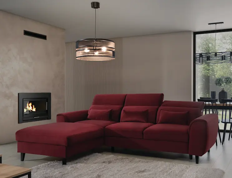 Narożnik Noble w kolorze burgundowym i lampa Orabela tworzą elegancki duet w nowoczesnym salonie z jasną podłogą i kominkiem.