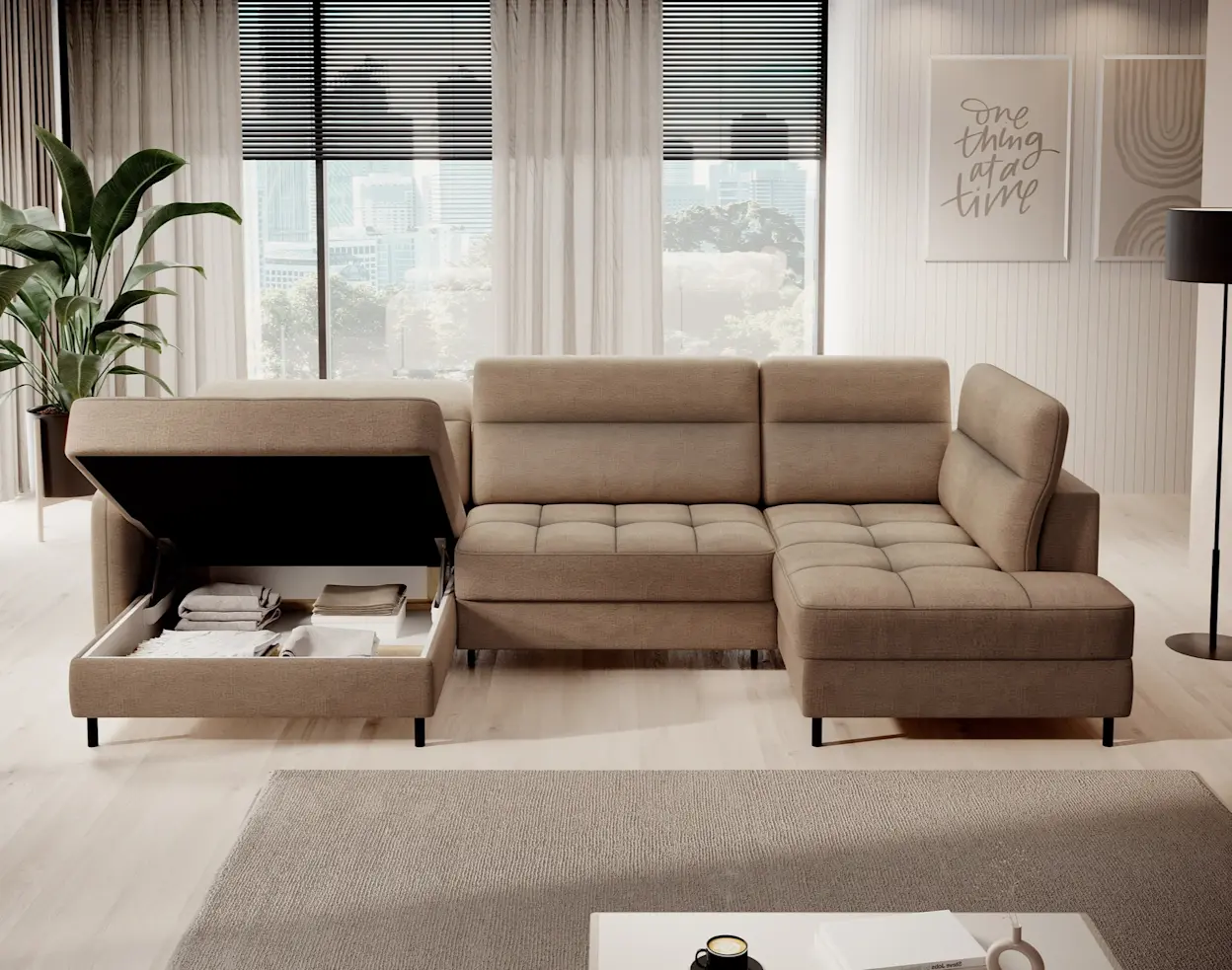 Beżowy narożnik Berrto w jasnym salonie z dużymi oknami i roletami. Sofa ma szezlong oraz otwarty pojemnik na pościel w lewym module, z widocznym miejscem na koce i tekstylia, idealnym do utrzymania porządku.