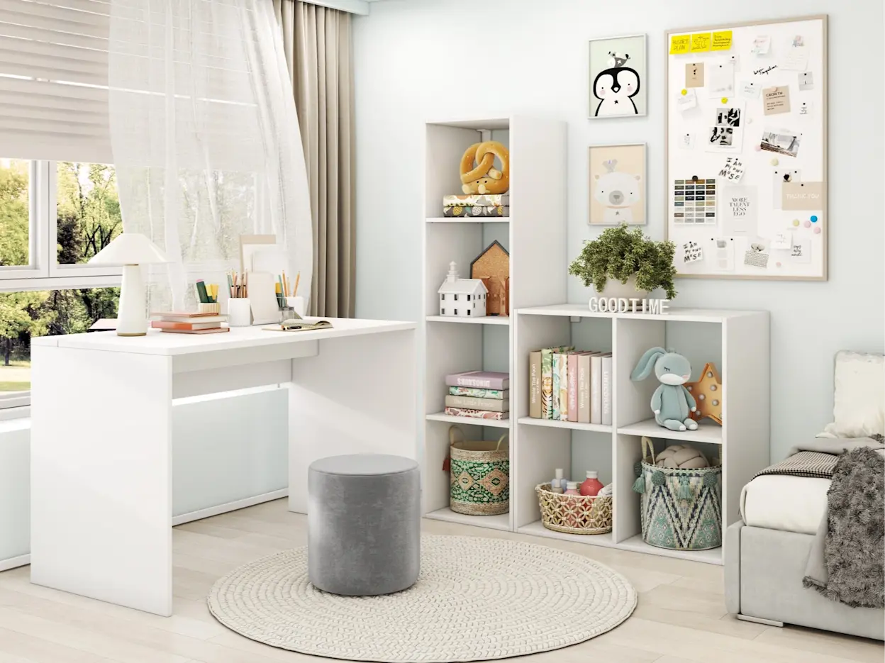 Nowoczesny pokój dziecięcy z białym biurkiem Nevy przy oknie oraz regałami Jugis i Figgi na książki i zabawki. W centrum stoi pufa Linsy Monolith 84, a jasne kolory i kosze ułatwiają utrzymanie porządku.