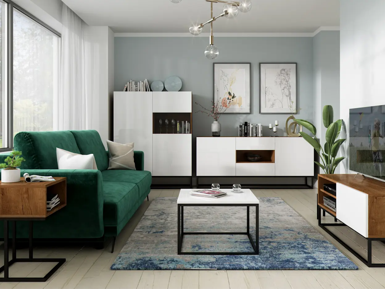 Zielona, welurowa kanapa Megis w jasnym salonie z białymi meblami i czarnymi stelażami. Aranżację dopełnia dywan w odcieniach niebieskiego oraz stolik kawowy, tworząc elegancką strefę relaksu.
